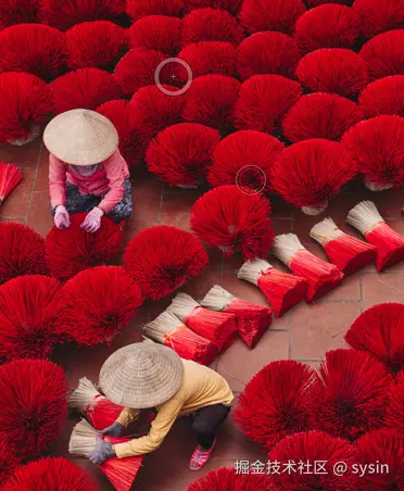 两名工人晾晒亮红色香束的照片。